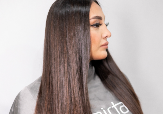 A woman with long, straight hair demonstrating the comfort and invisibility of extensions using the CombLine technique.